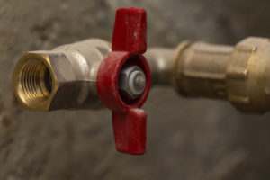 Close up of closed red ball valve brass on pipe